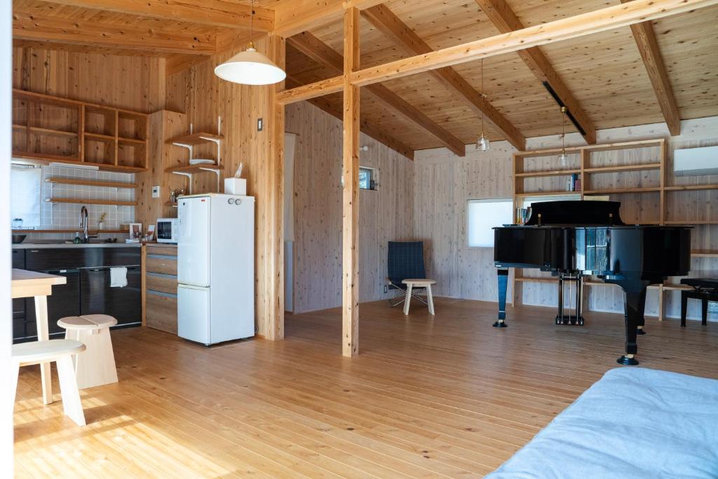 een keuken en een woonkamer met een witte koelkast bij Lotus Retreat ロータスリトリート 高知空港から車で35分 山のふもとの一棟貸しコテージ in Kami