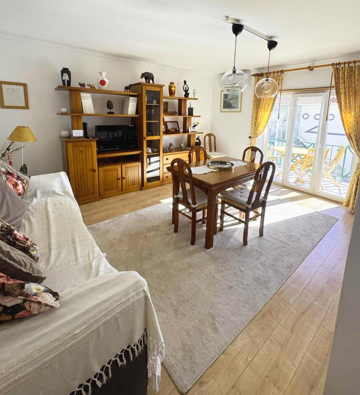 a living room with a table and a dining room at Ribeiro house in Lourinhã
