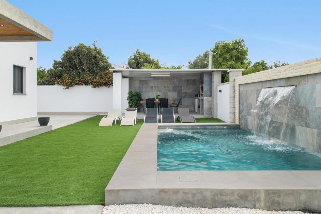 a backyard with a swimming pool and grass at Casa Jazmin in Campano
