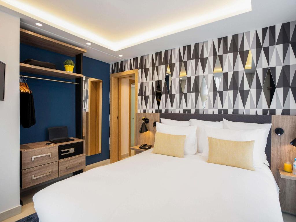 a bedroom with a large white bed and blue walls at Aparthotel Adagio Premium Casablanca City Center in Casablanca