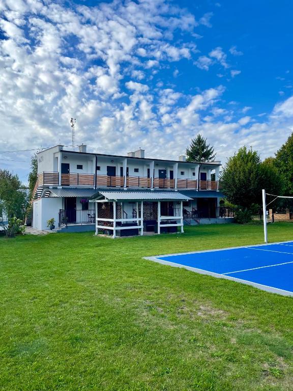 a building with a tennis court in front of it at Oaza Pieczyska in Koronowo