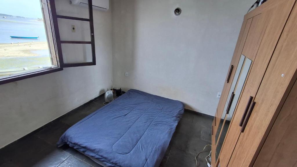 une petite pièce avec un lit et une fenêtre dans l'établissement Kitinet semi mobiliada ótima localização, à São Pedro da Aldeia