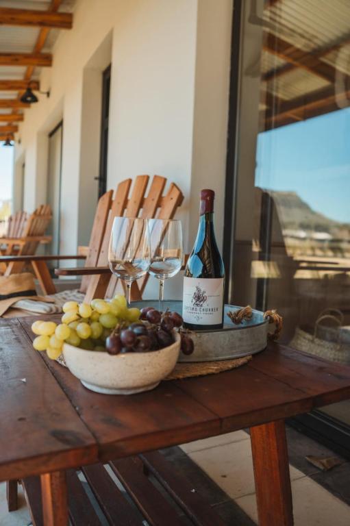 a table with a bowl of grapes and a bottle of wine at Bodegas y Viñedos Balcarce in Balcarce
