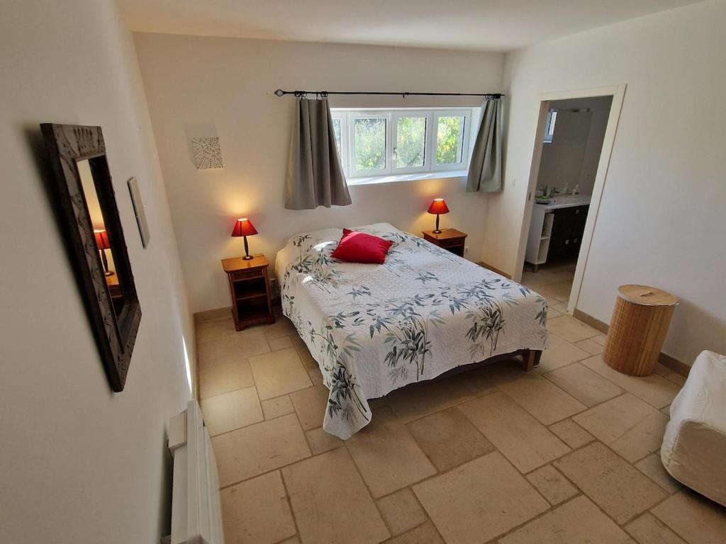 a bedroom with a bed and two lamps and a window at Hameau Grande Varenne - Gites de charme avec piscine in Charroux-dʼAllier
