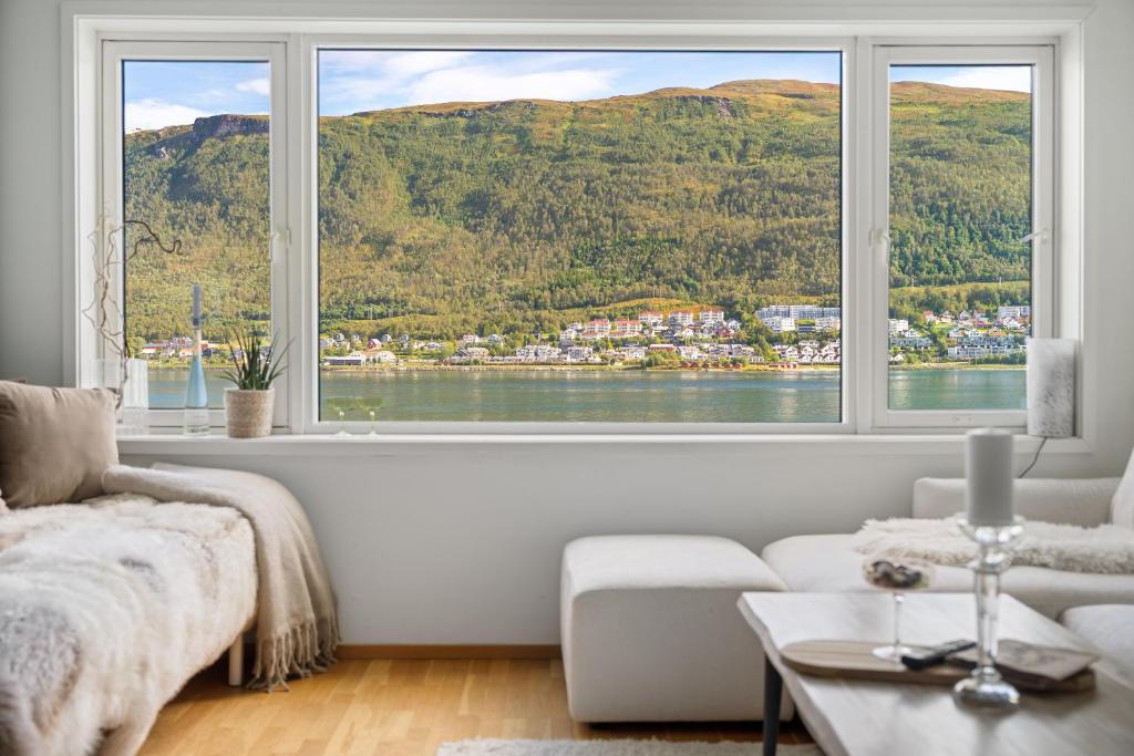 un salon avec une grande fenêtre avec vue dans l'établissement Costal Penthouse by Paramount, à Tromsø