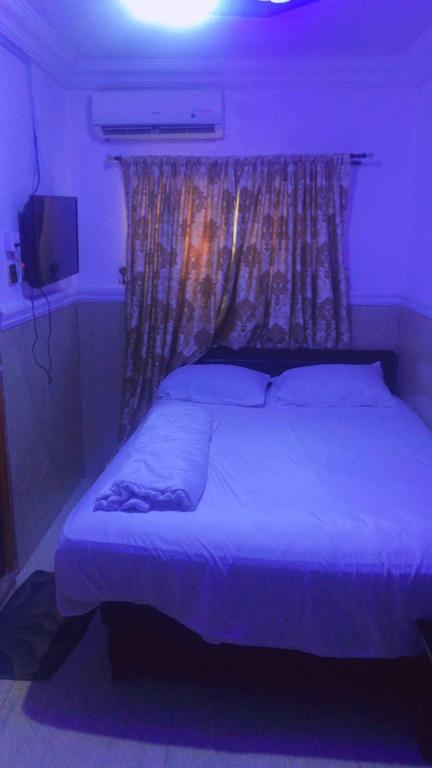 1 dormitorio con 1 cama grande con luz morada en Royal Castle hotel, en Lagos