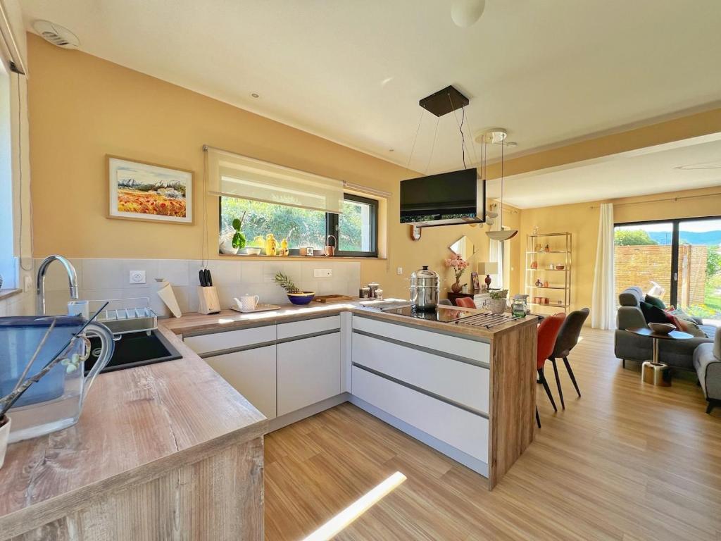 a kitchen with a counter and a living room at Maison moderne avec jardin au cœur du vignoble in Westhalten