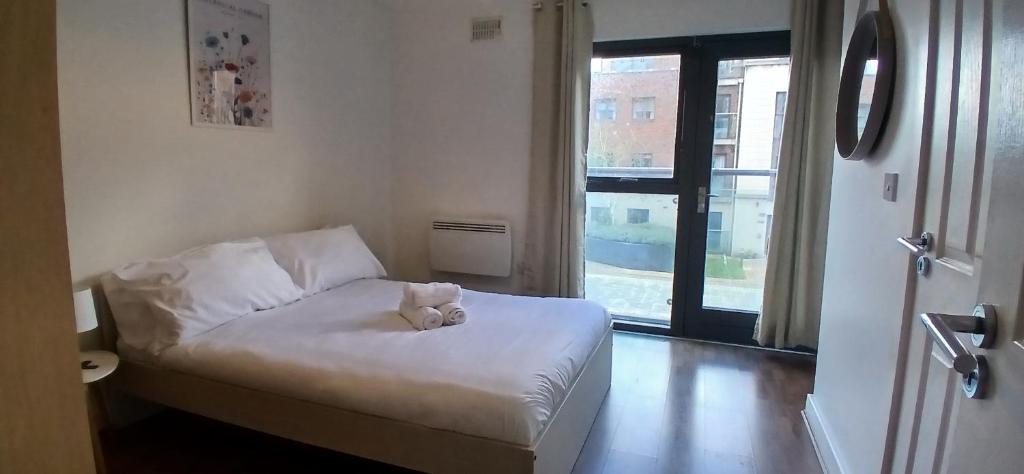 - un ours en peluche assis sur un lit dans une pièce dans l'établissement Spacious 2BR Apartment Only 15 Minutes to City, à Dublin