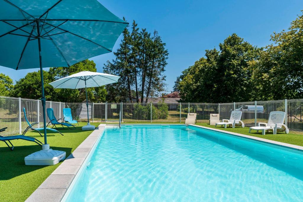 a swimming pool with chairs and an umbrella at Océan Ouest - Domaine Des Landes in Lesperon