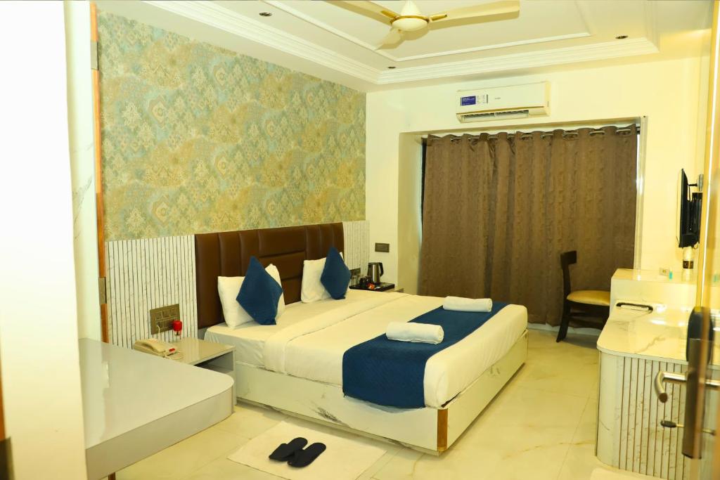 a bedroom with a bed and a tub in a room at Hotel Shirdi Park Inn 80 Meters From Sai Samadhi Temple in Shirdi
