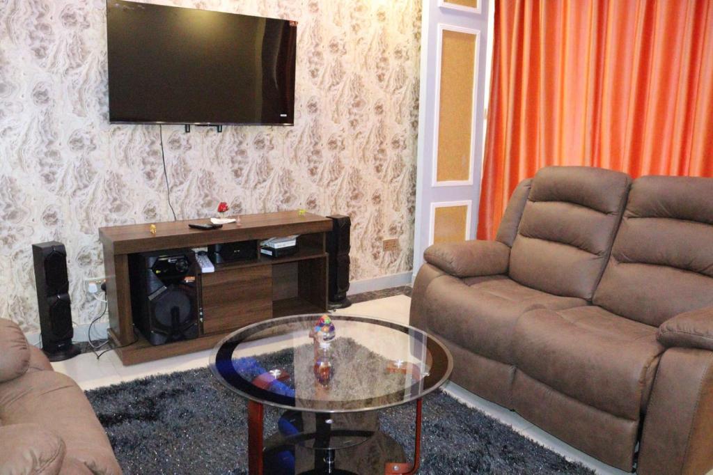 TV a/nebo společenská místnost v ubytování Executive fully furnished three bedroom apartment with ample parking space, swimming pool fully equipped gym children playing ground and amazing city views