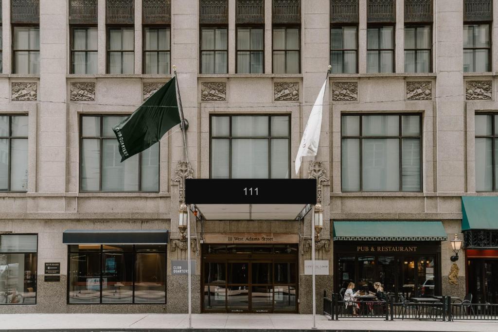 a facade of a building with flags in front of it at Club Quarters Hotel Central Loop, Chicago in Chicago
