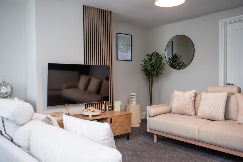 a living room with two couches and a flat screen tv at Vacant Nests The Beulah Town Centre Starlink in Allendale Town