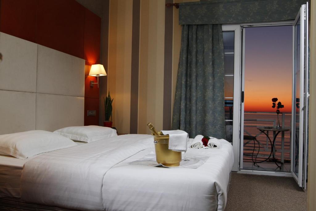 a hotel room with two beds and a large window at Bel Conti Hotel in Durrës