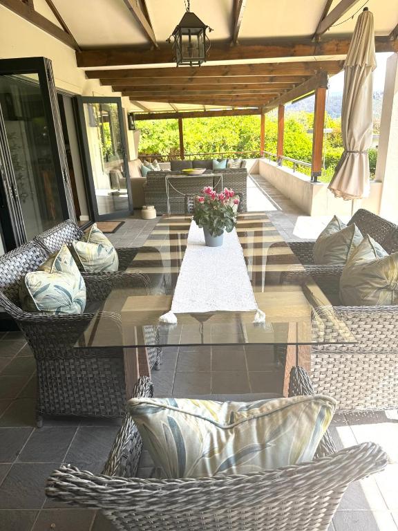 a patio with chairs and a table with a vase of flowers at 10onErika Franschhoek in Franschhoek