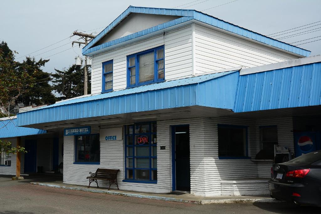 een blauw-wit gebouw met een blauw dak bij Bluebird Motel in Port Alberni