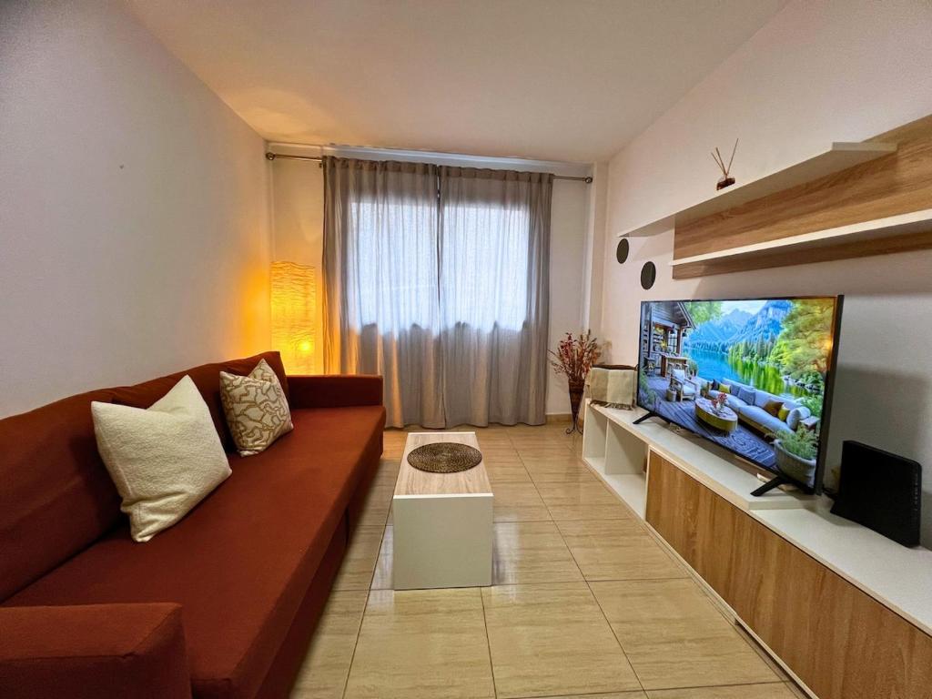 a living room with a couch and a flat screen tv at Rincón cálido in Adeje