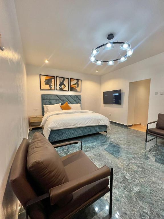 a bedroom with a bed and a couch and a tv at Xplora in Abuja