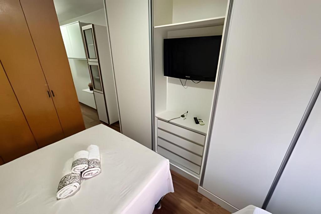 een kamer met een spiegel en een tafel met een tv bij Studio ao lado do Parque da Cidade - Brasília in Brasilia