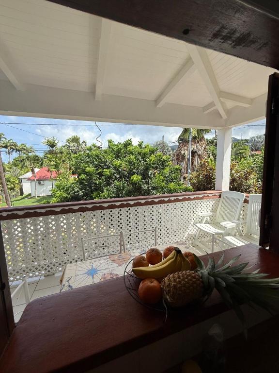 a bowl of fruit on a table on a balcony at Kaz à Zozio - F2 au calme à Bouillante in Bouillante