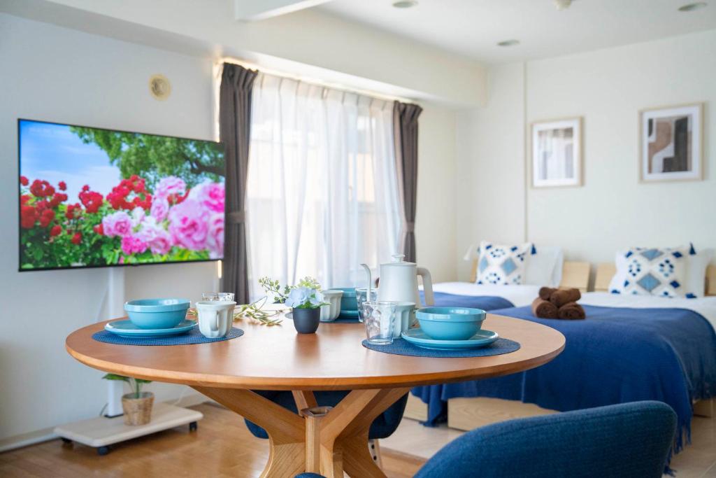 a living room with a table and a bed at ダイナスティパレス58 in Sapporo