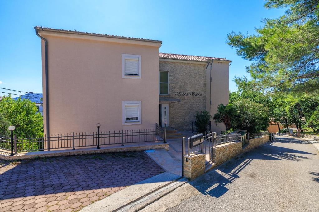 ein Gebäude mit einem Zaun davor in der Unterkunft Apartment Villa Sara in Dramalj