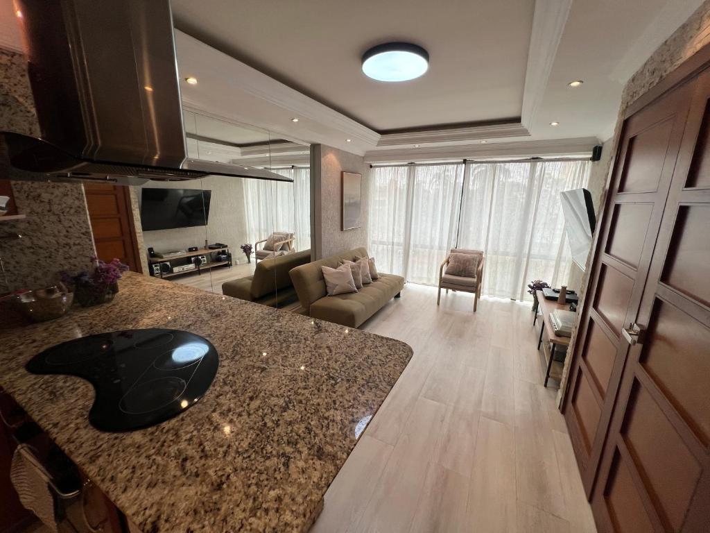 a kitchen and living room with a counter and a couch at Muy centrico, acogedor y como apartamento en La Viña a solo pasos de la AV BOLIVAR NORTE in Valencia