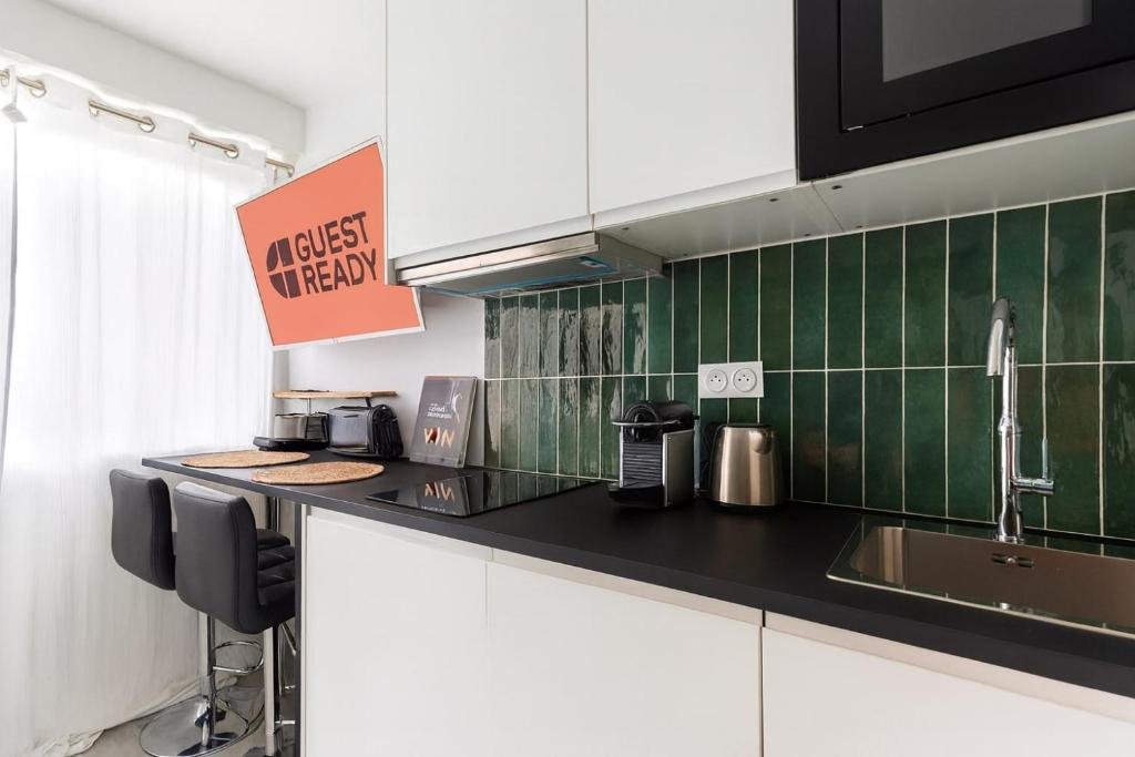 kuchnia z blatem i zielonymi kafelkami w obiekcie GuestReady - Mini studio tout équipé aux Chartrons w mieście Bordeaux