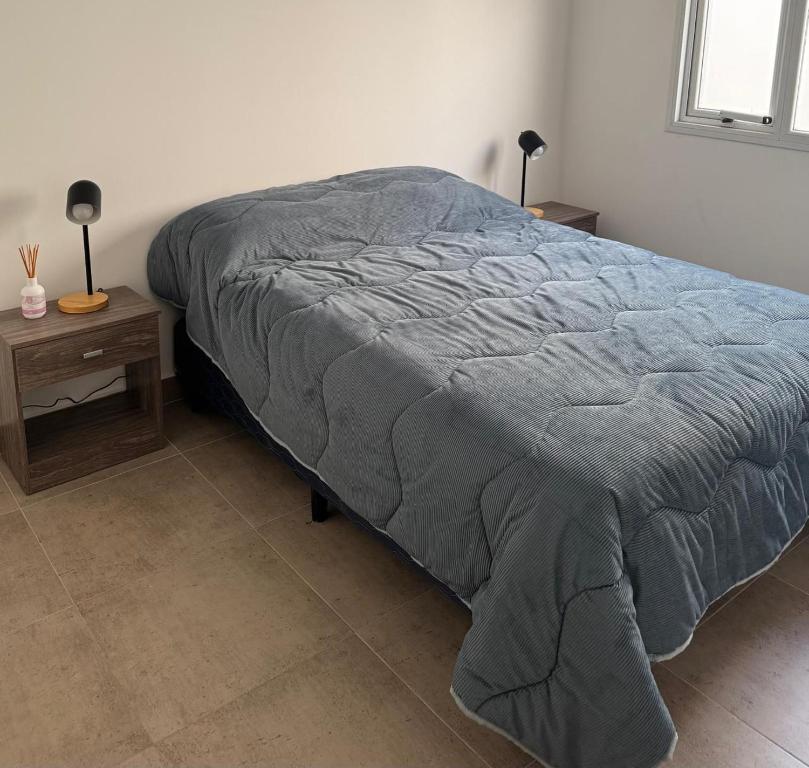 un letto in una camera da letto con due comodini e due lampade di CentroTrelew a Trelew