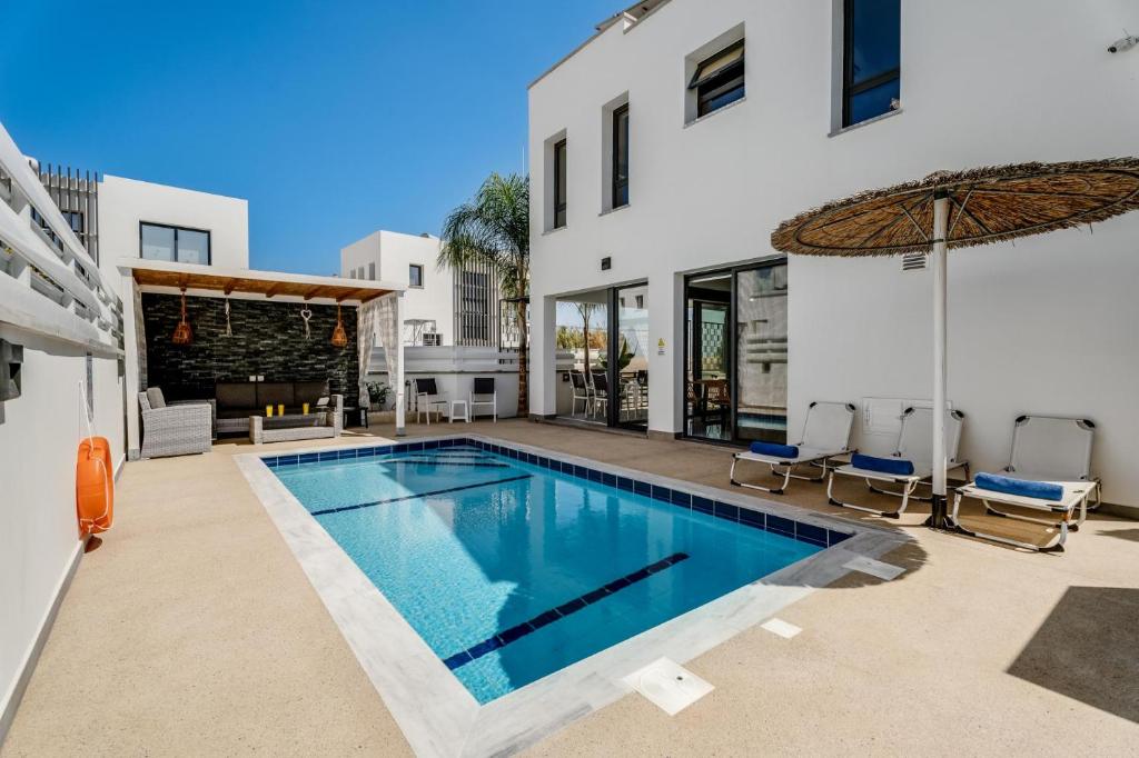 ein Swimmingpool im Hinterhof eines Hauses in der Unterkunft Villa Alassia 16 by Ezoria Villas in Paralimni