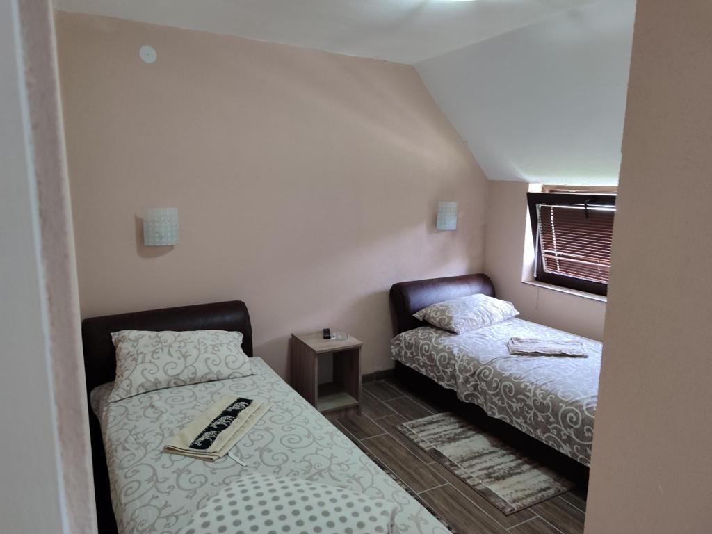 a small room with two beds and a window at Ur Njam-Njam in Vrnjačka Banja