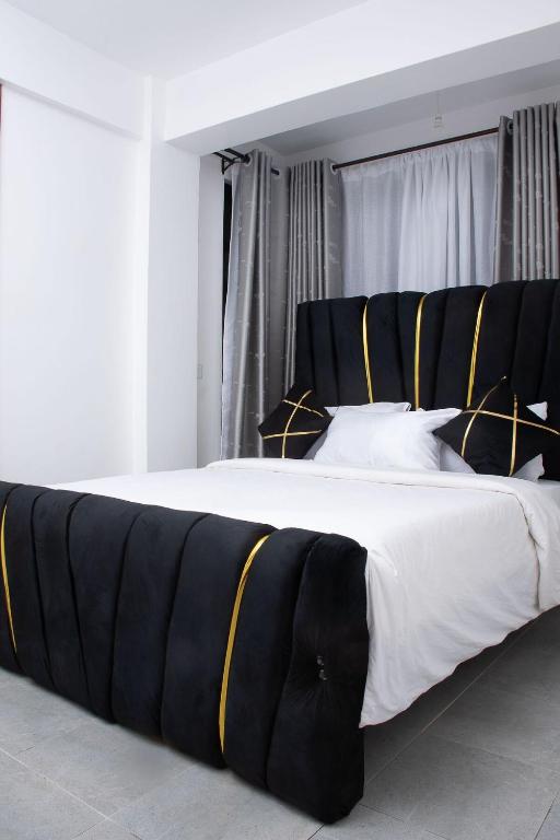a large bed with black and yellow stripes on it at Kayla Suites in Busia