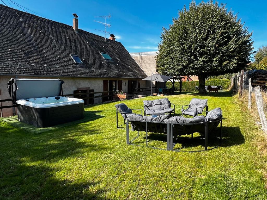 Un patio con dos sillas y un jacuzzi. en La Buissonnière, en Erckartswiller