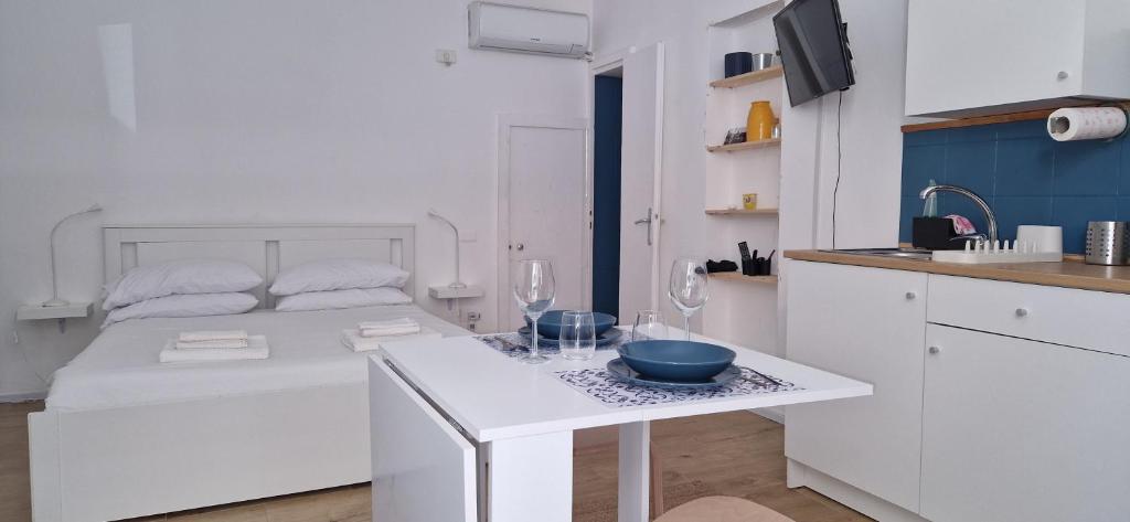een witte keuken met een wit bed en een tafel bij Suite San Giovanni in Rome