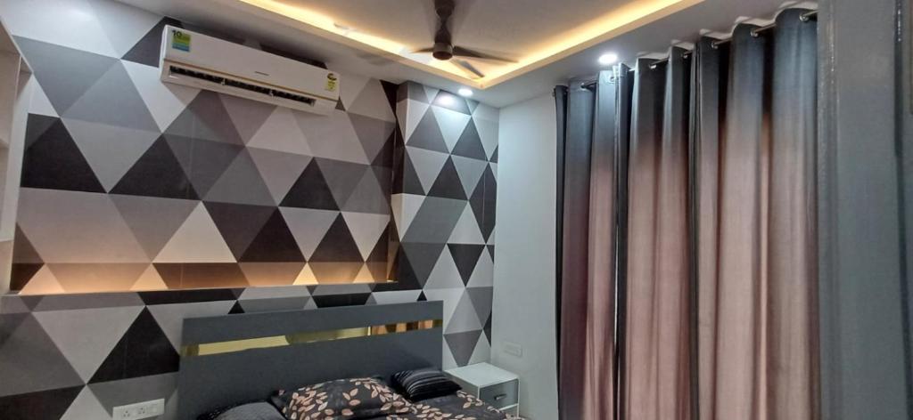 Un dormitorio con una pared de acento geométrico y una cama en Business Stay, en Māripat