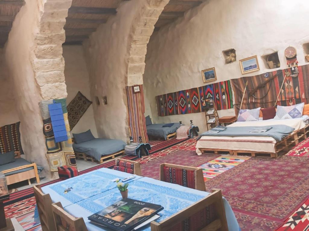 a large room with two beds and tables in it at Mumia heritage restaurant & house in Kerak