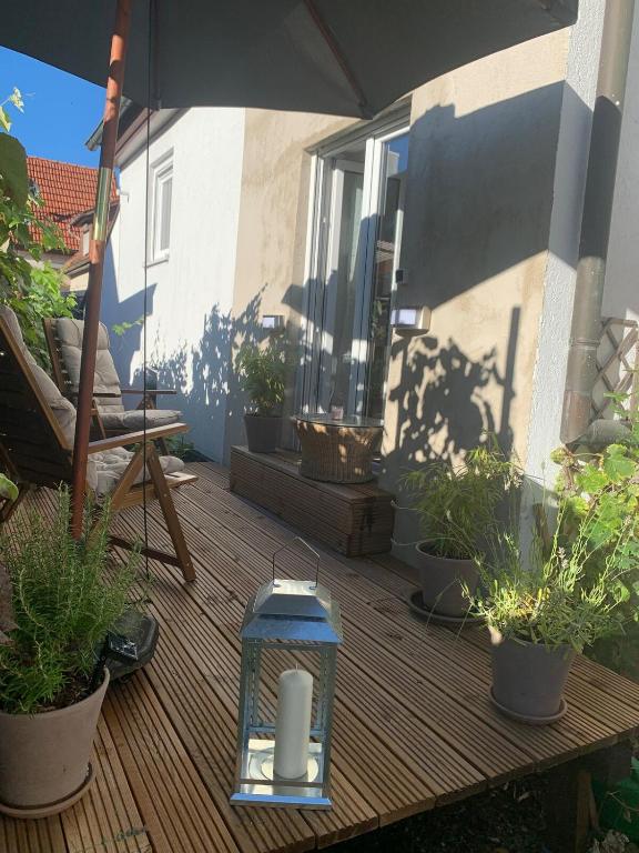 a patio with potted plants and a lantern on a deck at Auszeit Deluxe in Kirchheim unter Teck