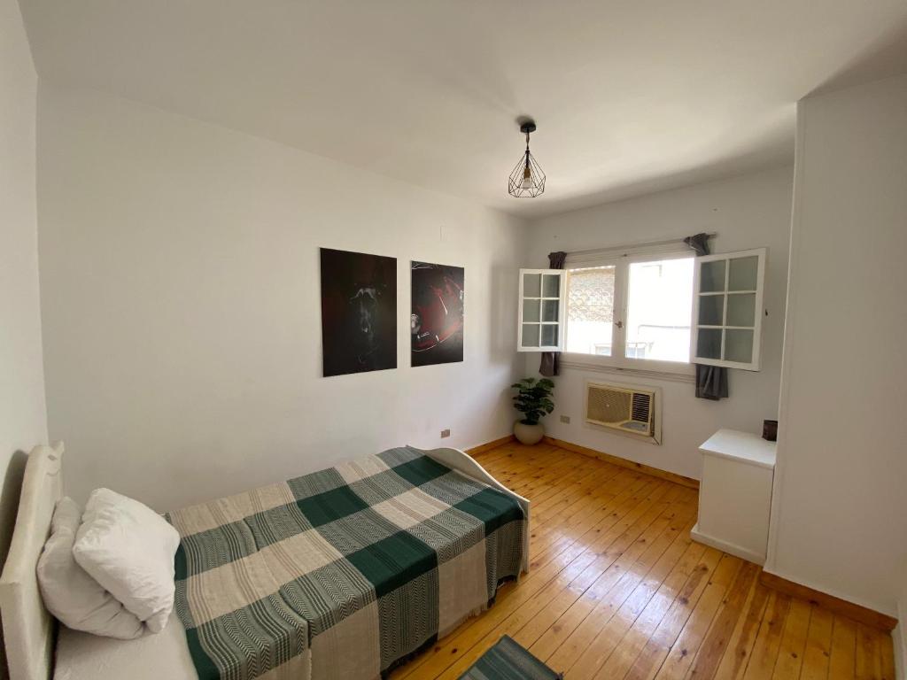 a white bedroom with a bed and a window at Villa Maadi 35 -R302- Double Room in Cairo