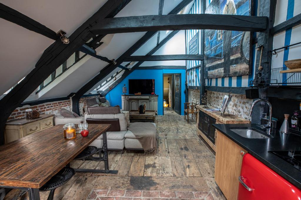a kitchen and living room with a table and a couch at La Petite Maison in Honfleur
