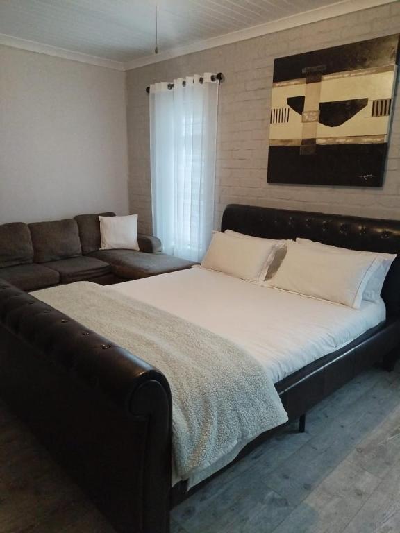 a bedroom with a large bed and a couch at Heaven Scent in Bettyʼs Bay