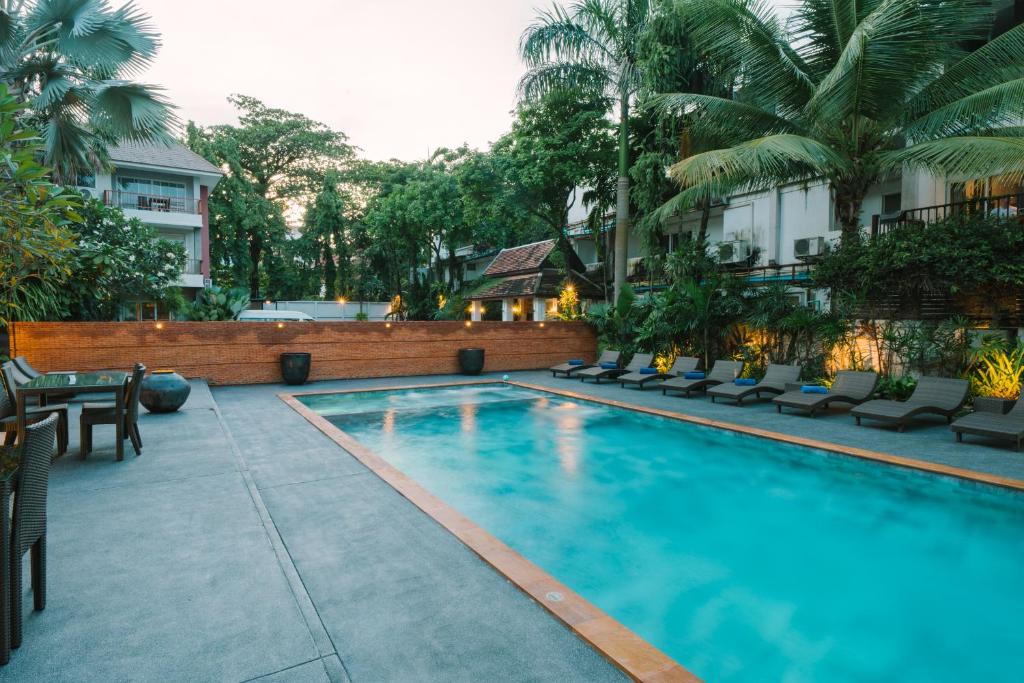 An evening view of the landscaped outdoor pool and surrounding loungers.