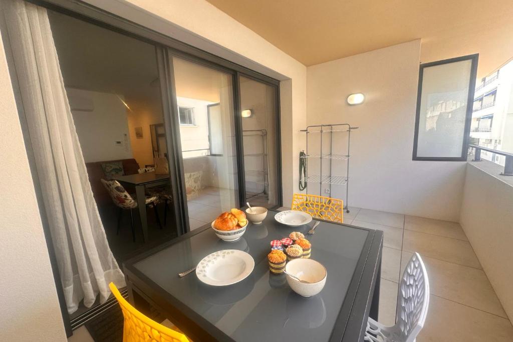 a table with bowls of food on it in a room at Villa Marie 2 Appartement tout confort climatisé 1 chambre proche plage in Le Grau-du-Roi