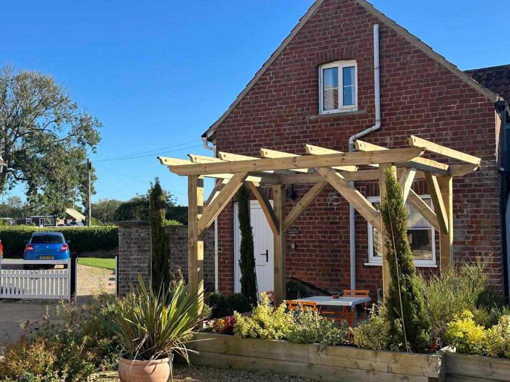 a wooden pergola on the front of a house at Harvest Cottage in Bridlington