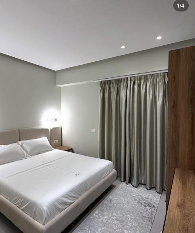 a bedroom with a white bed and a window at Art Rooms in Vlorë