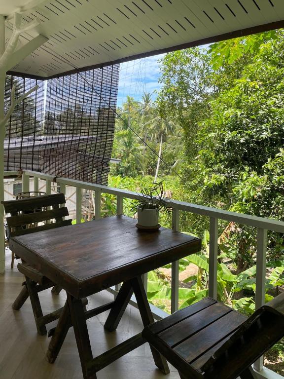 a wooden table and a bench on a porch at Simple Cozy House Coconut Lane in Hinkong