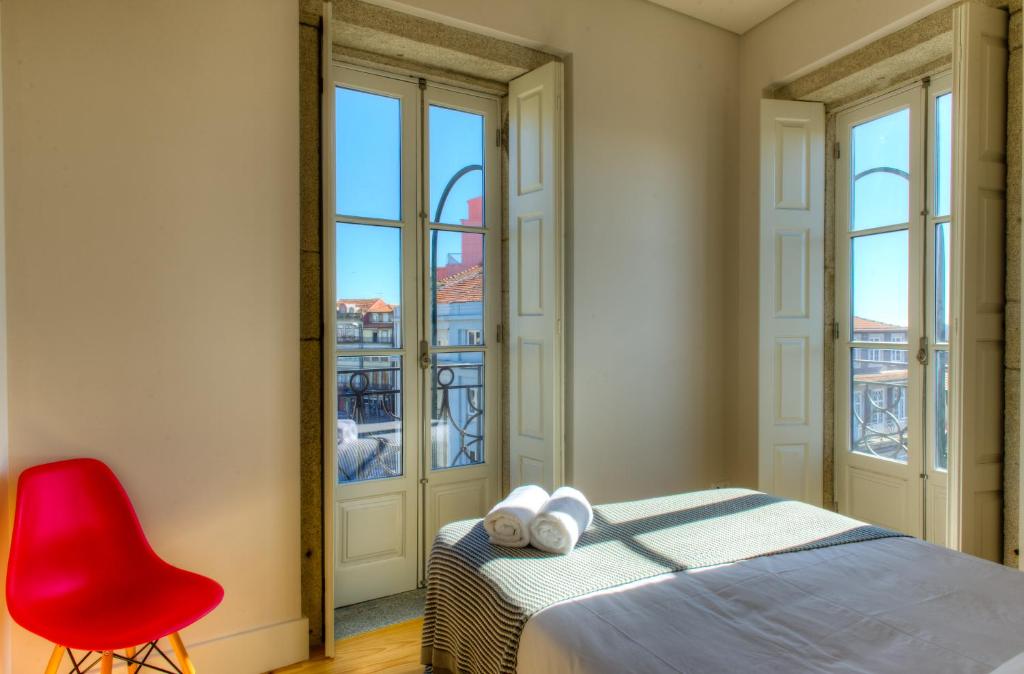 1 dormitorio con 1 cama y 1 silla roja en Porto Cinema Apartments en Oporto