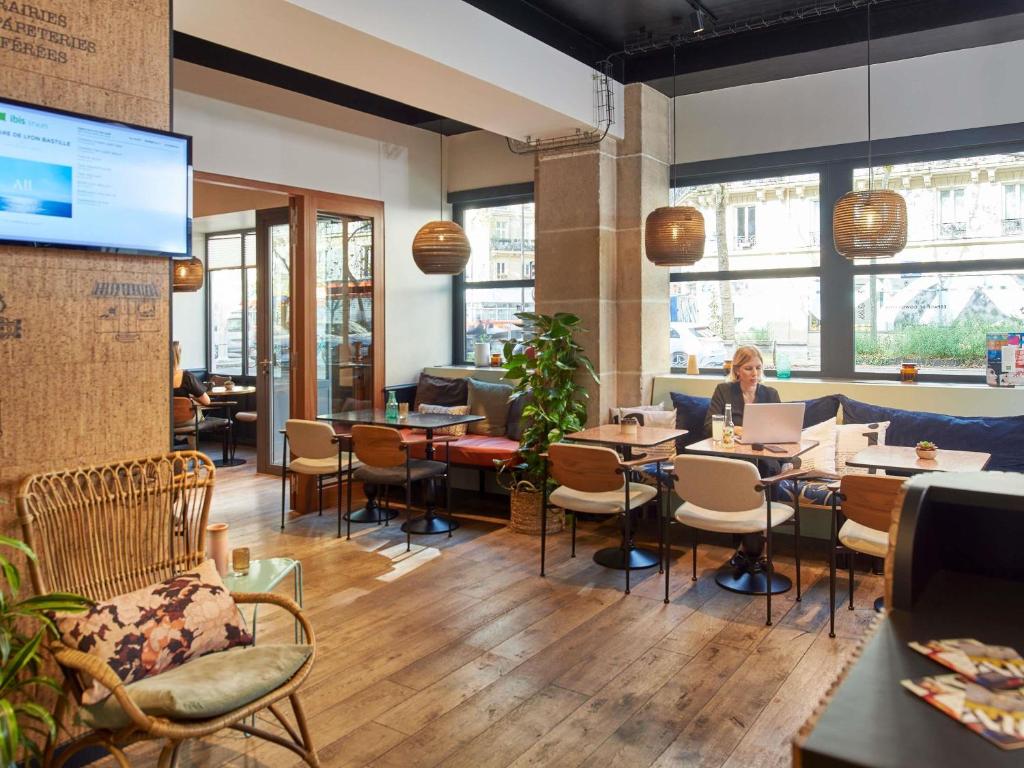 uma mulher sentada à mesa de um restaurante em Ibis Styles Hotel Paris Gare de Lyon Bastille em Paris