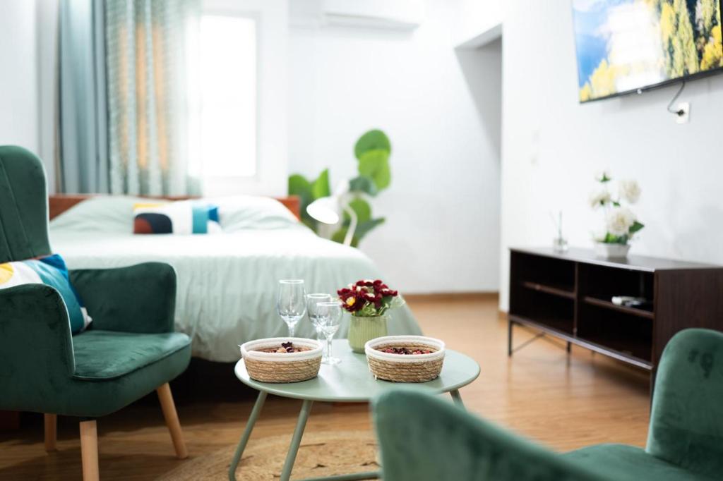 una camera da letto con un letto e un tavolo con due sedie di Green Haven - Modern Cozy Studio - Fast Wi-Fi - AC - Cocody a Abidjan