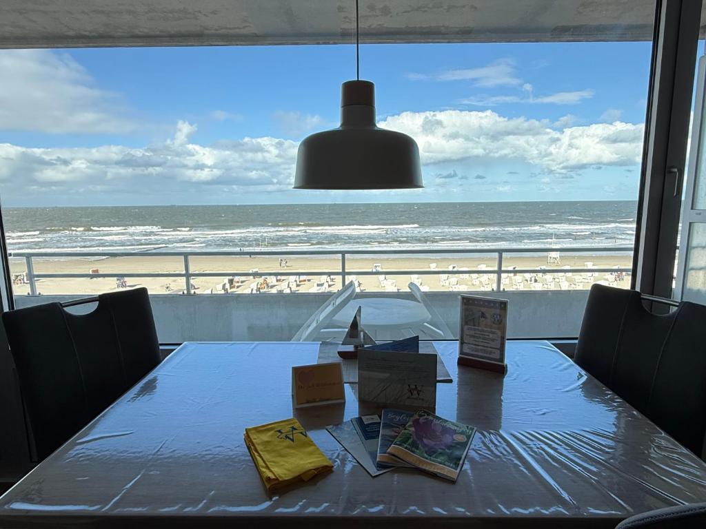 a dining room table with a view of the beach at Haus Monopol "Himmel und Meer" - direkter Meerblick mit Nord-Balkon in Wangerooge