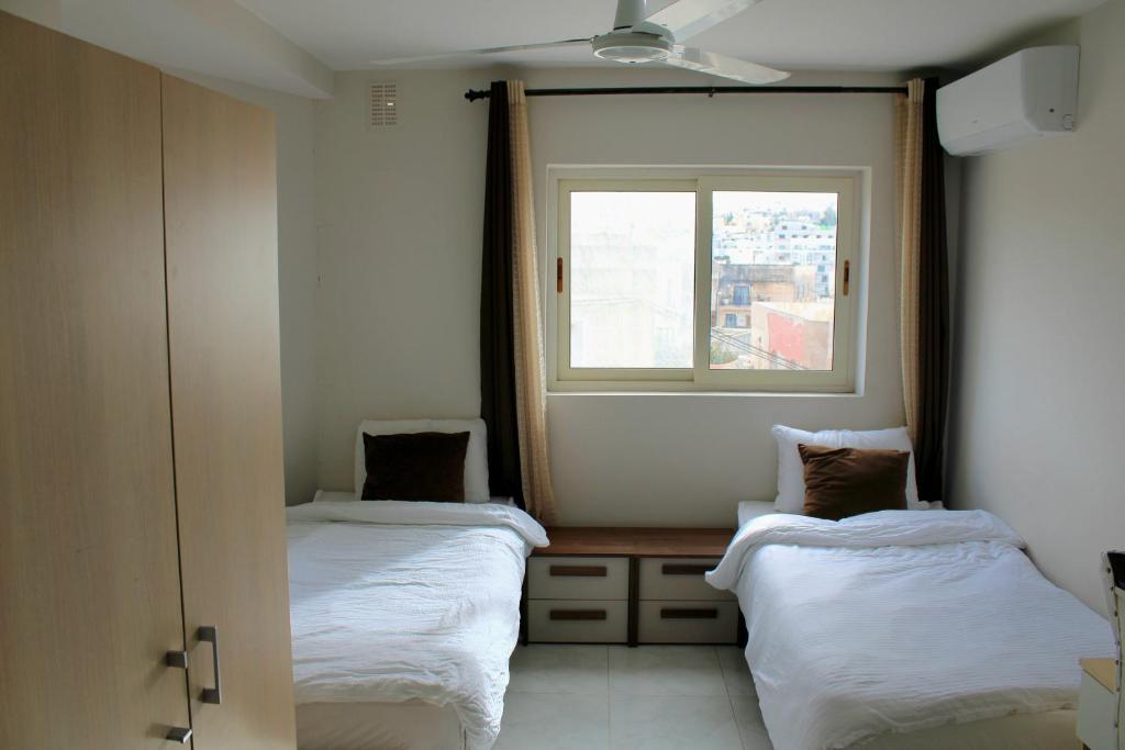 two beds in a room with a window at Twin Room with Private Bathroom - Room 6 in Tal-Għoqod